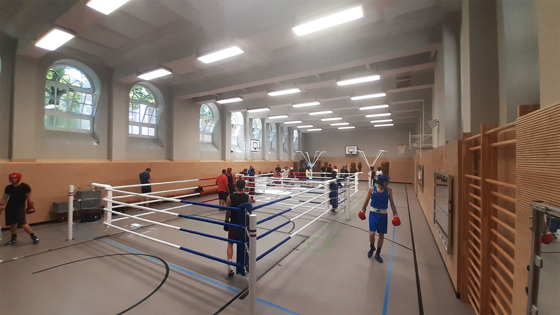 Die Boxhalle des FC St. Pauli am Zeughausmarkt beim Trainingswochenende mit Vereinen aus NRW. In zwei Ringen findet gleichzeitig Sparring statt. Im Hintergrund arbeiten Boxer ans Sandsäcken.